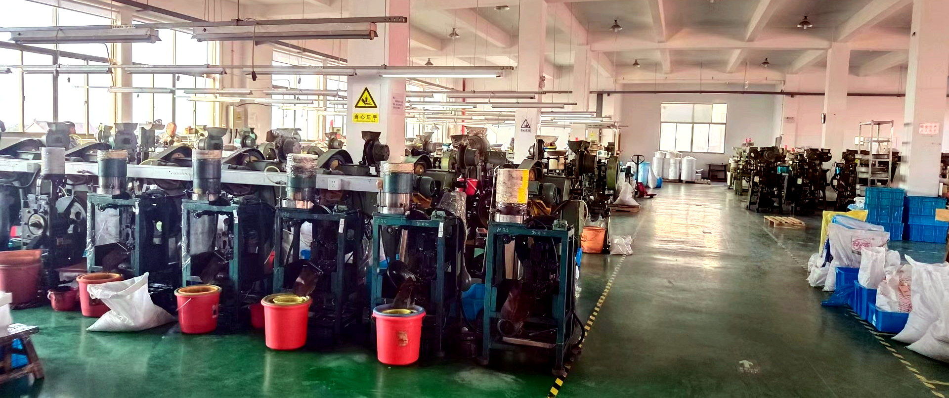 Rows of button production machines on the workshop floor at our Ruian button factory
